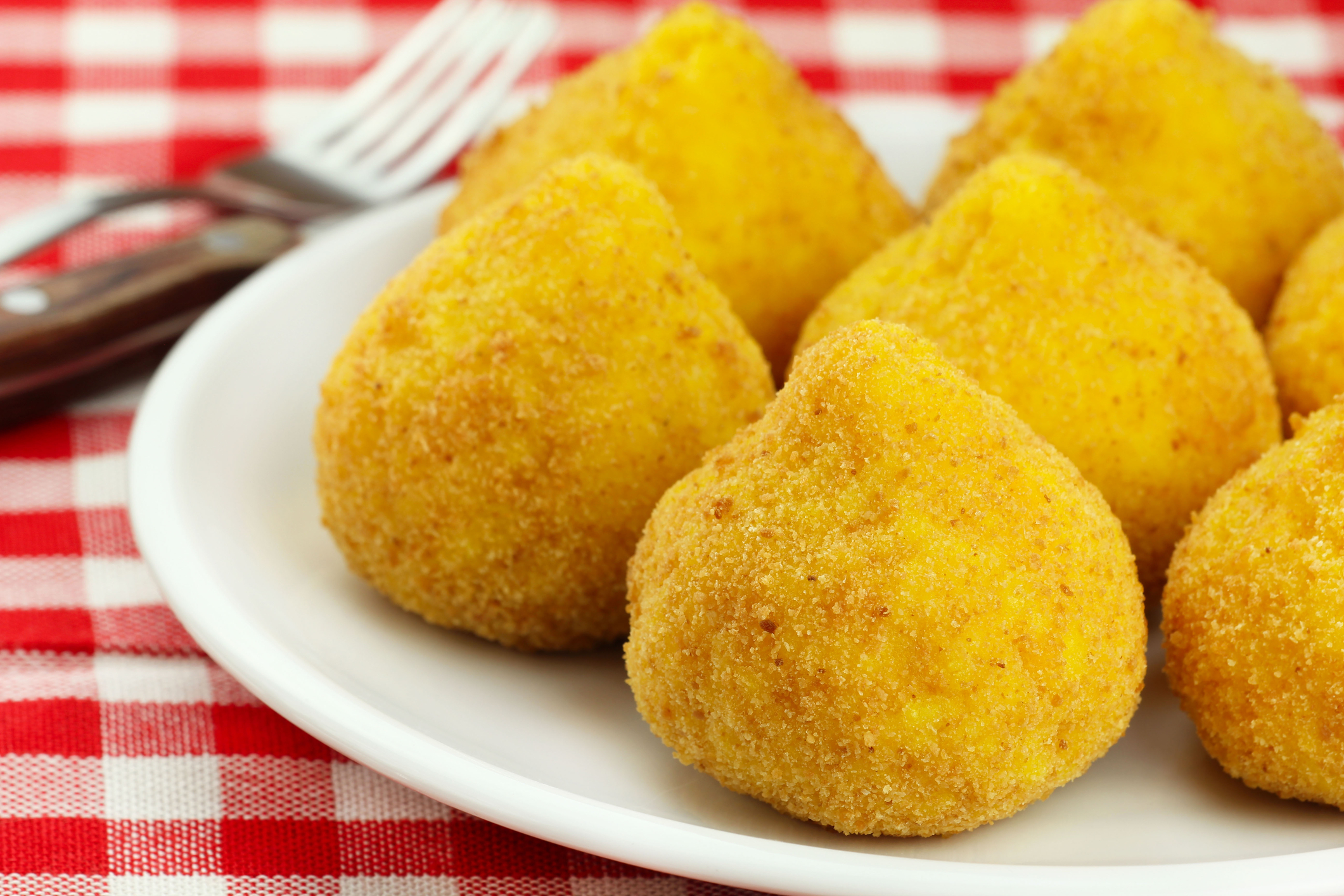 Assortiment d’arancini siciliens servis en street food.